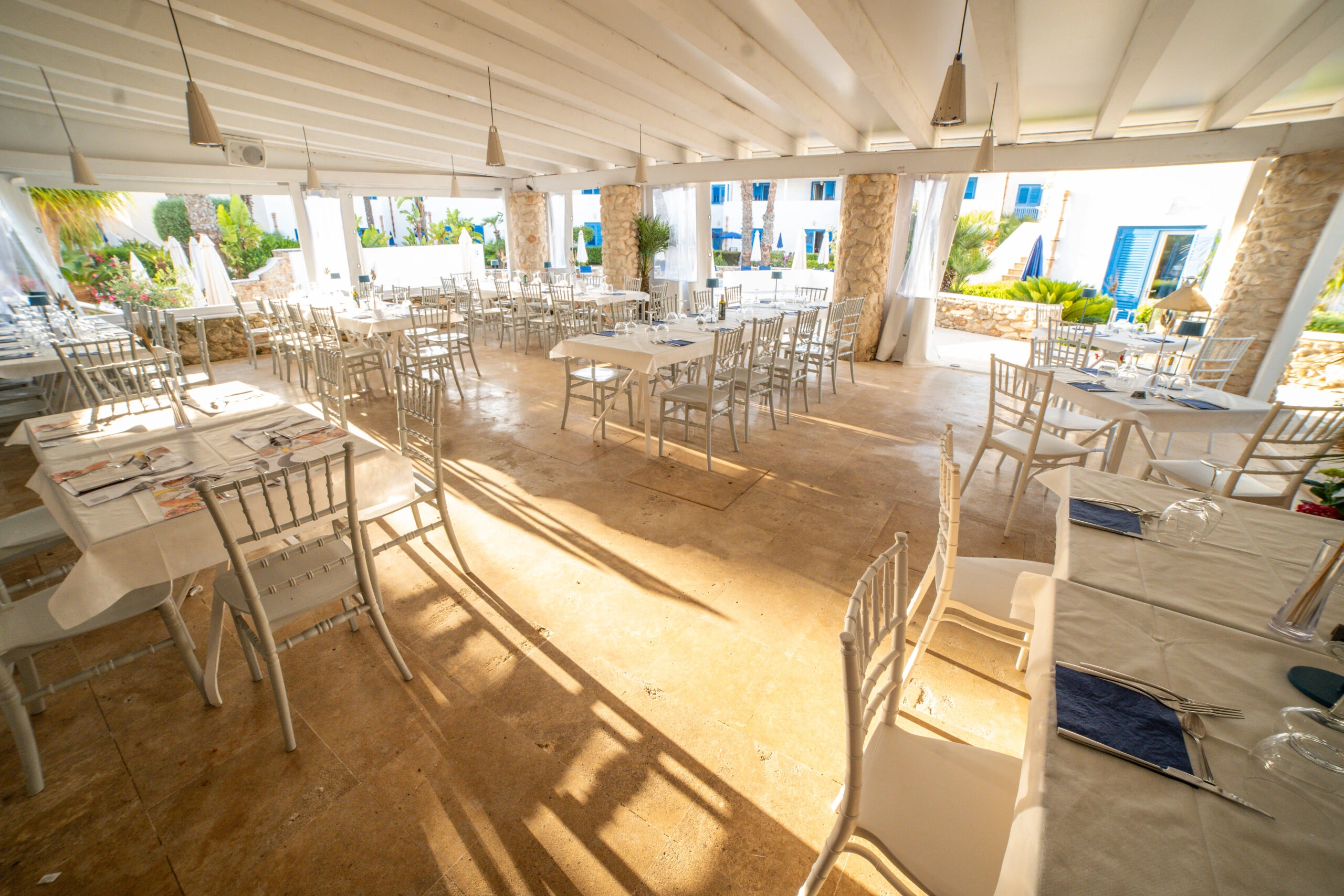 Veduta della sala del ristorante Poseidon con tavoli e sedie bianche
