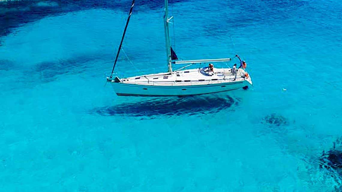 Barca a vela sul mare turchese delle isole Egadi